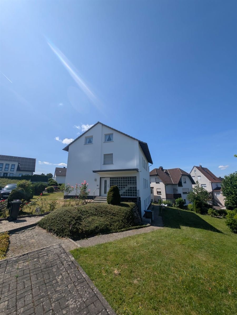 Weißes Einfamilienhaus mit gepflegtem Vorgarten