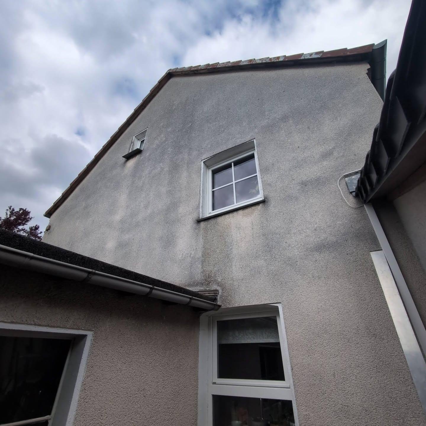 Verwitterte graue Altfassade vor der Sanierung