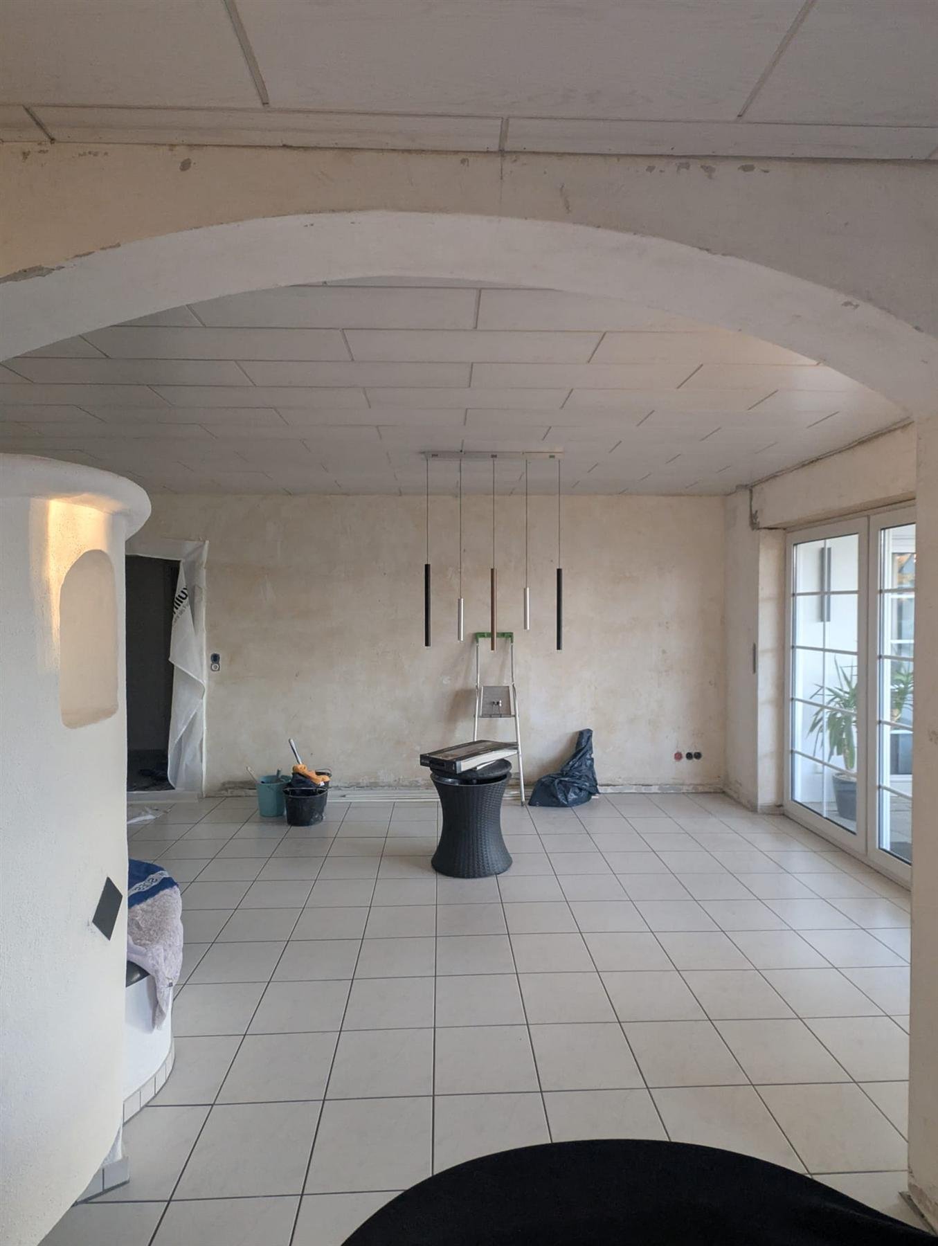 Leerer Rohbauraum mit altem Fliesenboden vor der Renovierung