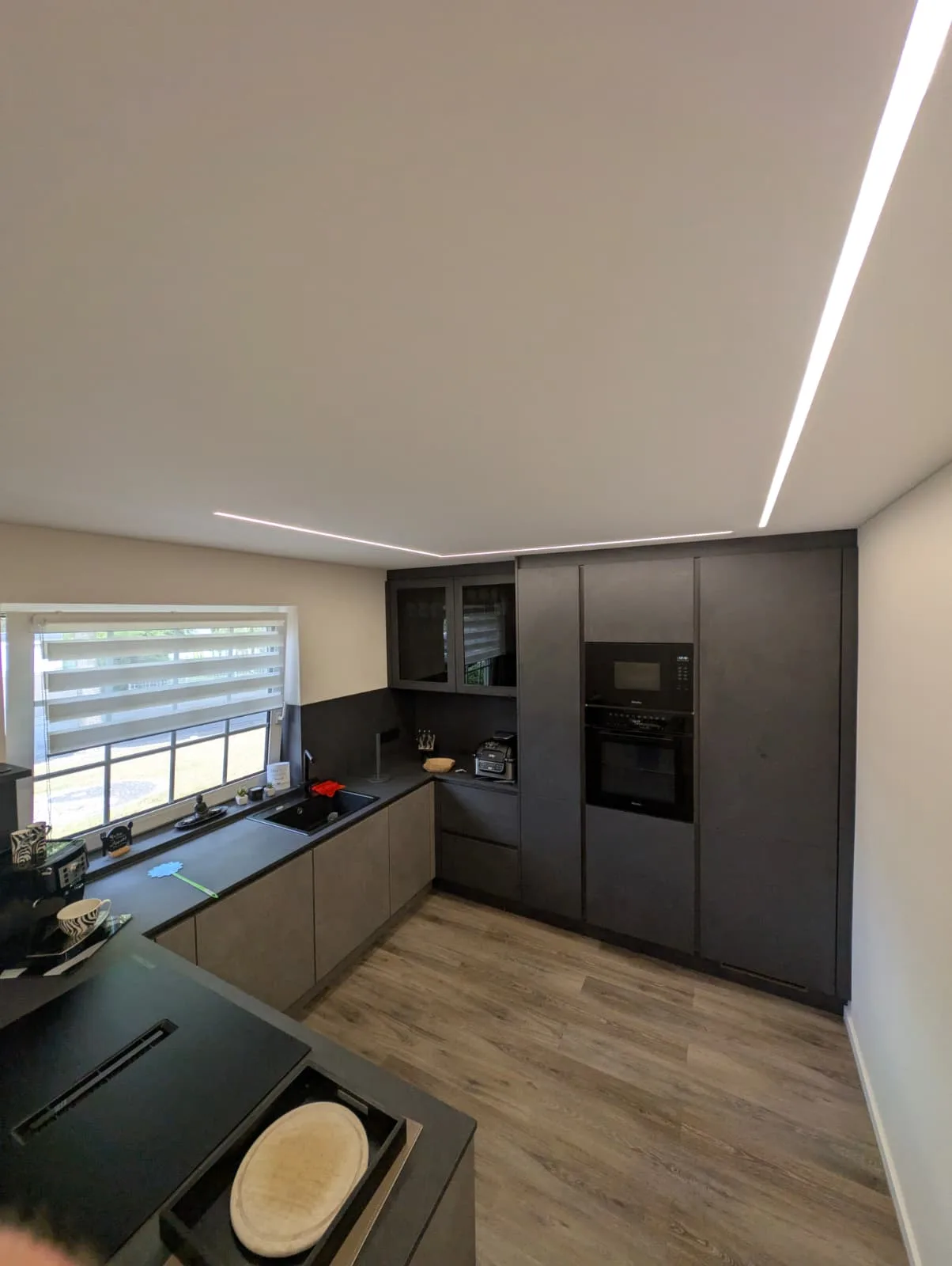 Moderne anthrazitfarbene Küche mit indirekter LED-Beleuchtung