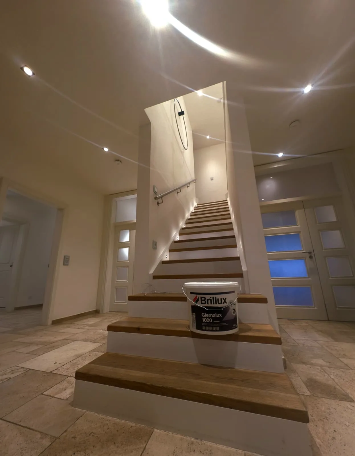 Frisch lackierte Treppe in einem Treppenhaus mit Travertinboden