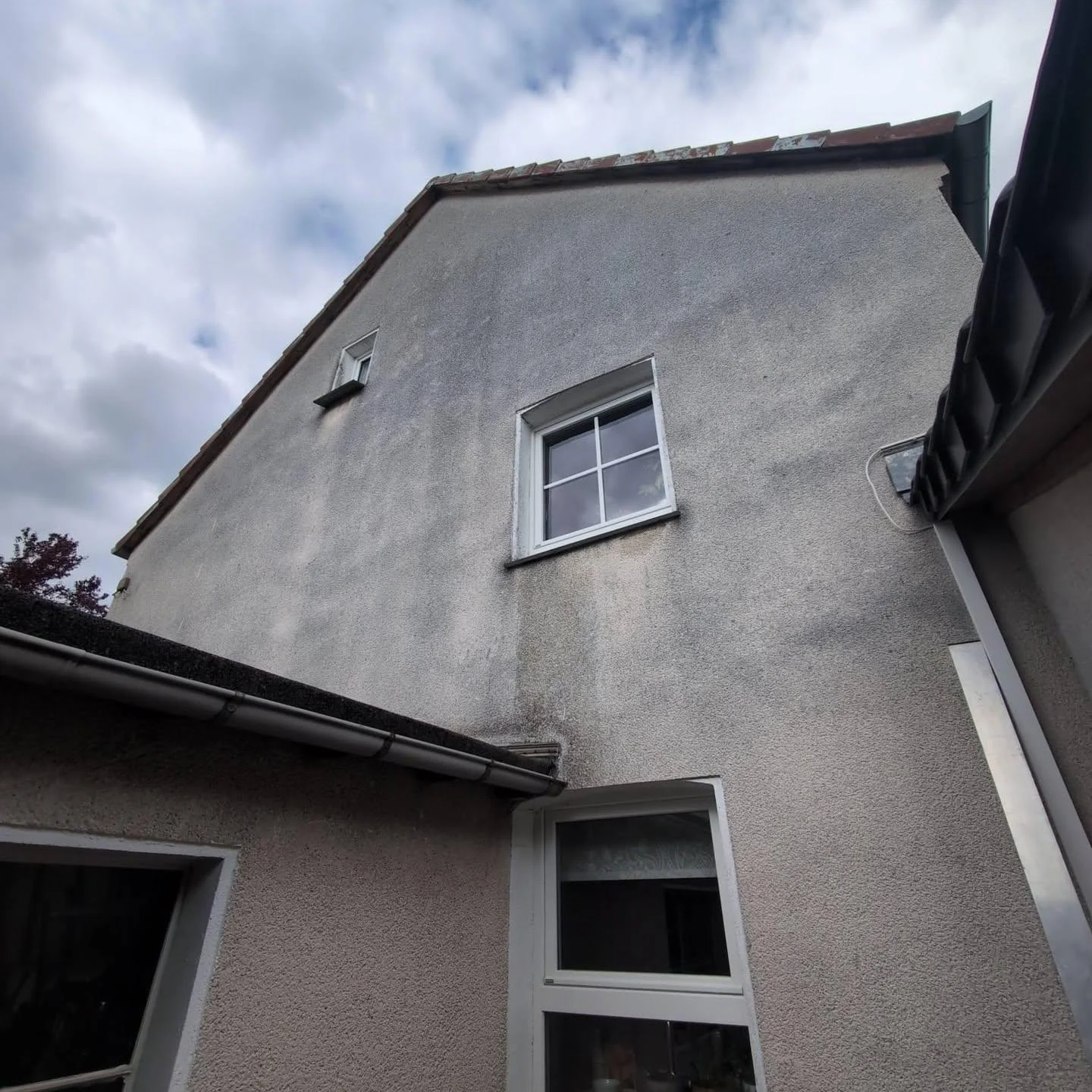 Verwitterte graue Altfassade vor der Sanierung
