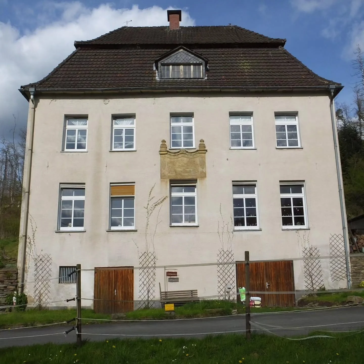 Historisches, unrenoviertes Putzgebäude mit Sandsteinrelief vor der Fassadenerneuerung